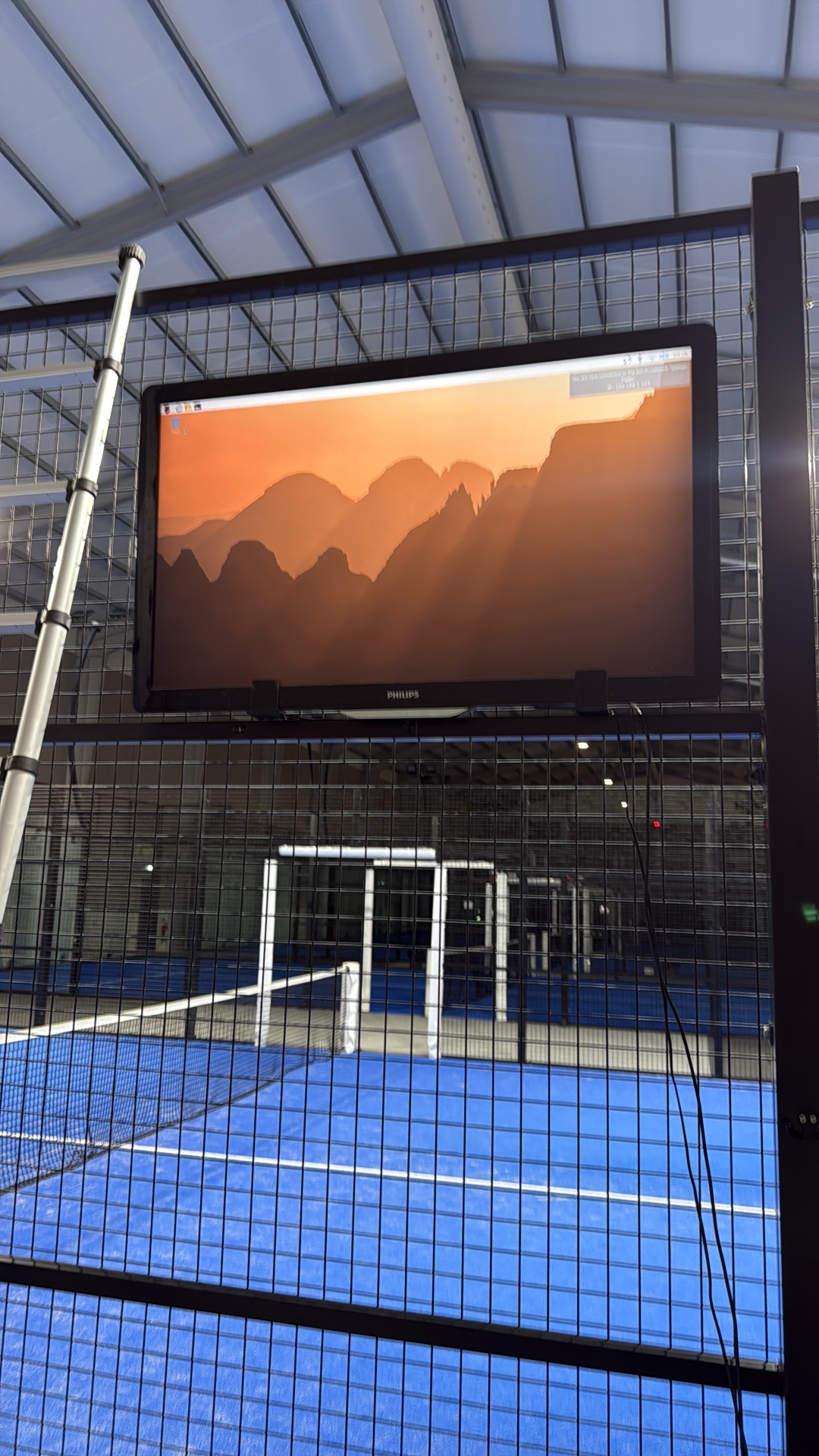 Courtside screen next to a padel court showing GameCam playback